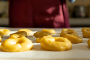 Sort of raw dough on the table prepared to be baked with the cooker on the background.
