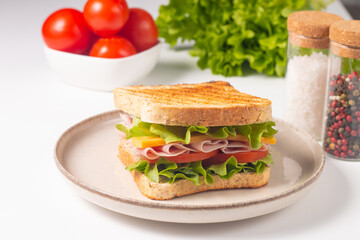 Close-up of two sandwiches with bacon, salami, prosciutto and fresh vegetables on rustic wooden cutting board. Club sandwich concept - 750911205
