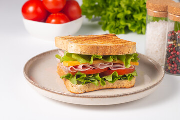 Close-up of two sandwiches with bacon, salami, prosciutto and fresh vegetables on rustic wooden cutting board. Club sandwich concept - 750911216