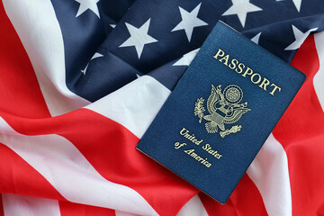 Blue United States of America passport on national flag background close up. Tourism and citizenship concept
