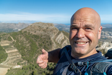  Smiling hiker takes a selfie outdoors in the mountains