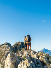 Two hikers walk along the mountain ridge
