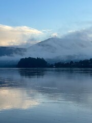 Mist-covered mountain reflected in a serene river Minho during early morning hours, Tabagón, O Rosal, Galicia, Spain, January 2023