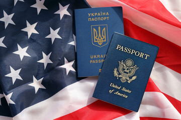 Naklejka premium United States of America and Ukrainian Passports on folded US flag close up