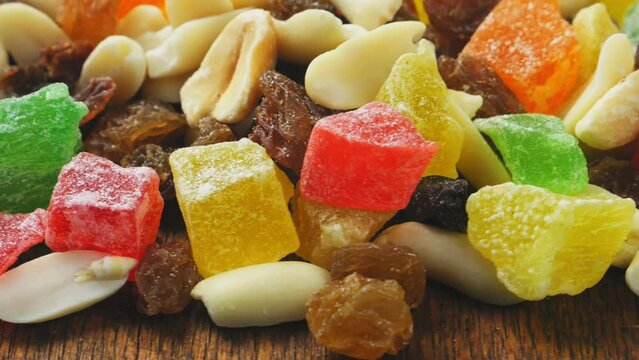 dried fruits, candied fruits and nuts rotate in a circle. Close-up.