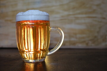 bright large pint of beer in wooden background