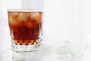   closeup fizzy soda with icecubes in a glass , highkey bright white background