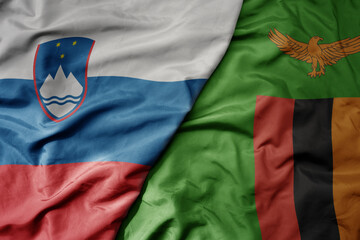 big waving national colorful flag of zambia and national flag of slovenia.
