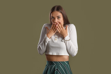 Scared young woman on green background