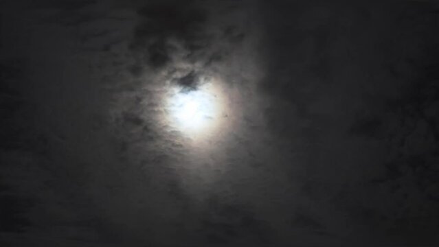 Captivating night sky video with full moon, clouds moving, creating eerie atmosphere. Sequence highlights full moon, clouds in a moody, dark setting. Ideal for full moon, clouds visuals