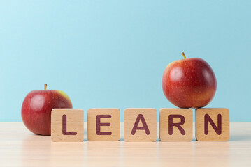 Apples and 'LEARN' blocks on a blue background - 750933280