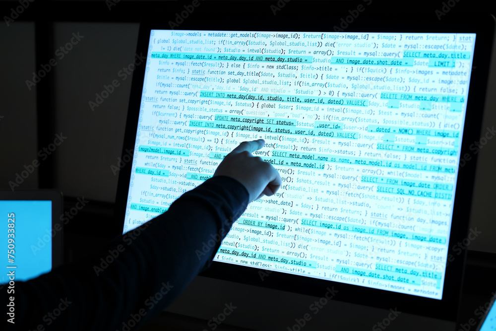 Poster hacker pointing at computer screen in dark room, closeup