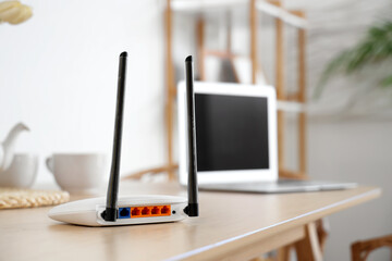 Modern wi-fi router on dining table in light room, closeup