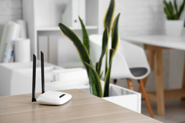 Modern wi-fi router on desk in office, closeup - obrazy, fototapety, plakaty