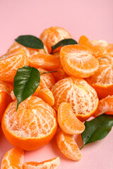 Heap of fresh tangerines with leaves on pink background