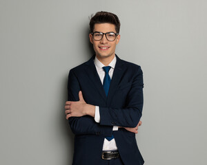 confident businessman wearing glasses with arms folded