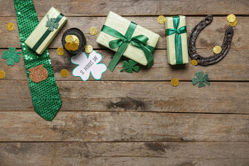 Gift boxes with tie, pot of golden coins and horseshoe for St. Patrick's Day celebration on wooden...