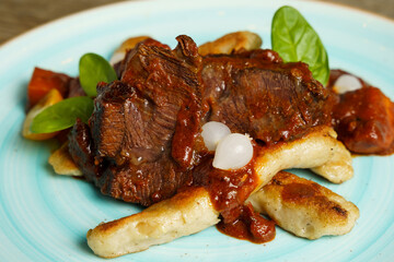 Cooked beef with vegetables on a wooden table
