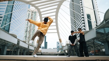 Group of professional street dancer cheer up while asian hipster perform freestyle footstep at city surrounded by people with low angle camera. Break dance concept. Outdoor sport 2024. Sprightly. - obrazy, fototapety, plakaty
