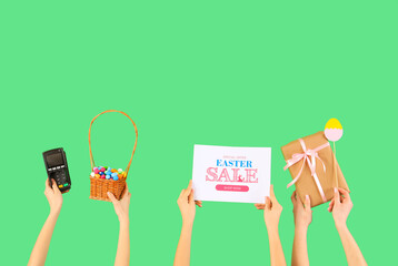 Women with payment terminal, eggs and gift on green background. Easter Sale