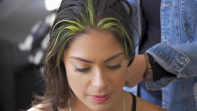 Hairdresser prepares model hair for photo shoot session at studio