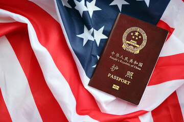 Red passport of People Republic of China on United States flag. PRC chinese passport on bright...