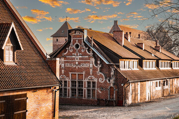 Street in the Baltic village. Old brick abandoned house in the traditional style