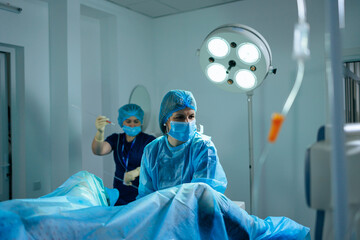A female doctor performs an operation in a sterile operating room. Surgical intervention operation....