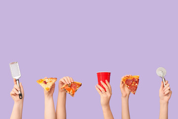 Many hands holding tasty pizza slices, pizza cutter, grater and one-use cup on lilac background