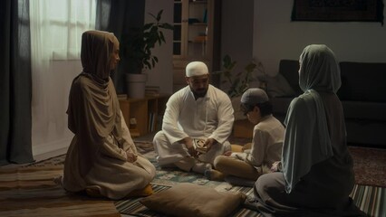 Full footage of father in white muslim cap and kandora explaining basic rules of islam with Koran in hand to little son. Sister and mother sitting nearby in hijabs and listening