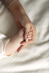 baby's hand in mother's hand, concept of happy family and motherhood