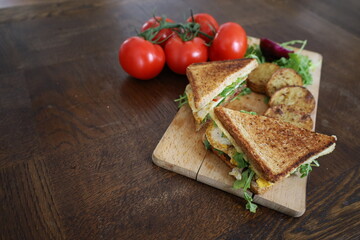 homemade club sandwich with vegetables and baked potatoes