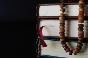 Islamic concept background. Dark brown prayer rosary beads and holy Quran.