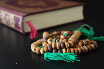 Islamic concept background. Dark brown prayer rosary beads and holy Quran.