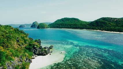 Aerial view 4k drone shot of small islands and beaches around Calauit National park Coron island, the Philippines. Crystal clear turquoise blue waters, palm tree lined white sandy beaches, and visible