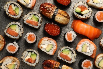 Different tasty sushi rolls on grey table, flat lay