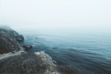 A person standing on top of a cliff by the ocean. Perfect for travel or inspirational concepts