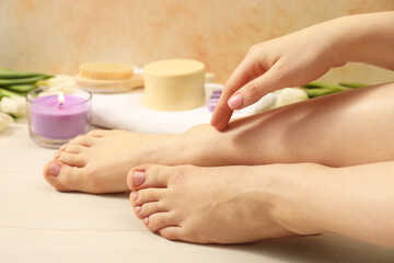 Woman with neat toenails after pedicure procedure on wooden floor, closeup