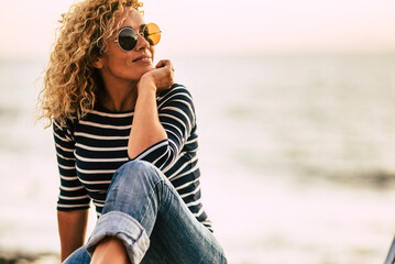 Pretty woman sitting outdoor with a bike having relax leisure activity with beach in background....