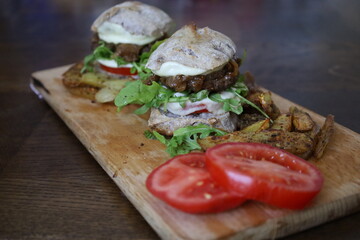 home made rustic mini burgers and baked potatoes on wooden board