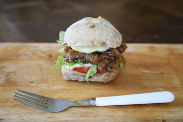 home made rustic mini burger and baked potatoes with fork on wooden board