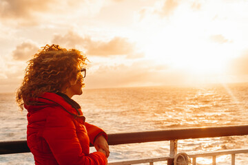 Travel people concept lifestyle. One woman admiring sunset light on the ocean standing on the ferry...