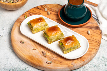 Pistachio baklava with turkish coffee on rustic table, ramadan or holiday desserts concept. Middle Eastern cuisine flavors