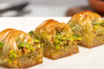 Cimcik baklava. Mediterranean cuisine flavors. Pistachio baklava with turkish coffee on rustic table, ramadan or holiday desserts concept. Close up