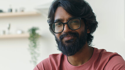 Close up ethnic Arabian Indian smart man in eyeglasses homeowner renter tenant apartment 30s...