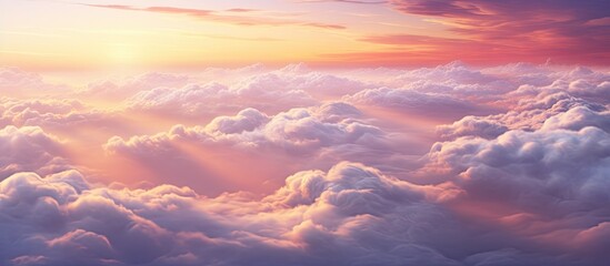 Fototapeta premium The sun is breaking through a layer of clouds in the sky during a gorgeous sunset cloudscape viewed from above. Sunlight streams through the clouds creating a dramatic and beautiful scene.
