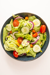 Fresh healthy green salad with tomatoes and vegetables in front view isolated clean background