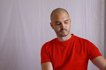 casual bald man in red shirt with closed eyes