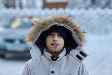 Young Boy Standing in Snowy Parka © justoomm