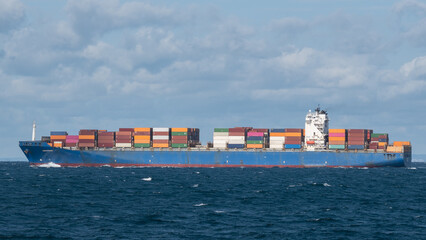 Large container ship with white superstructure at sea.